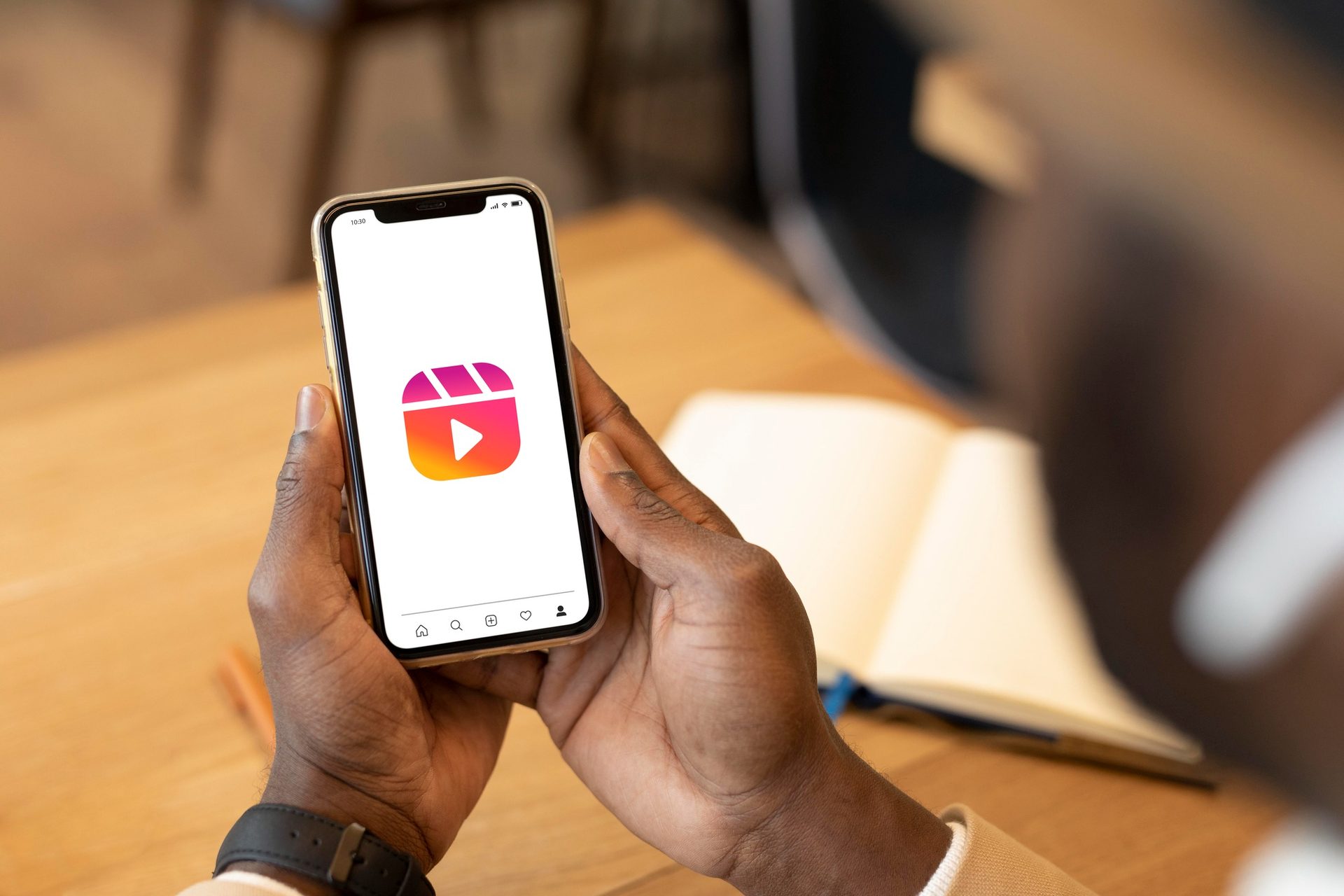 GIME Stream app open on a phone, held in hand, video thumbnails visible on screen.