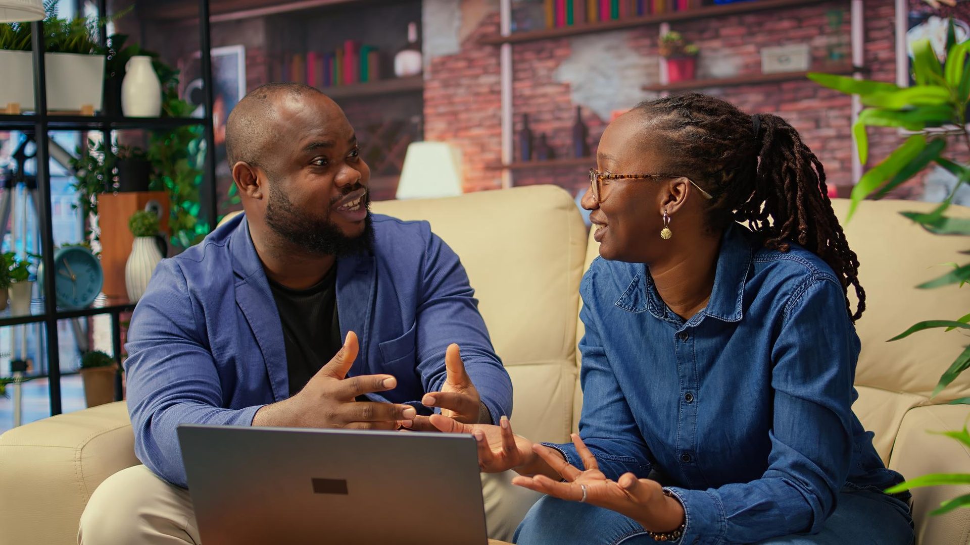 Artist and manager reviewing a tour/release plan on a laptop in a studio lounge.